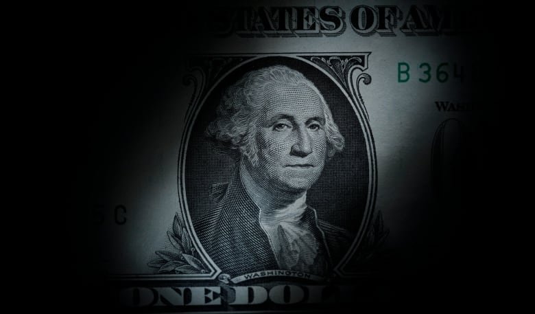 nerdwallet-millennial-money-partner-credit-score A close-up of American money with George Washinton's portrait in the middle and the edges of the picture faded to black.