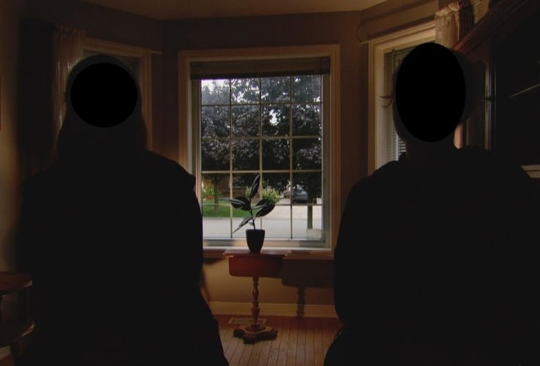 unnamed-14-year-old-passenger-and-her-mother Two people sit in chairs with their backs to the camera. They are in shadow and their faces are not visible. They are looking out a living room window to the street outside.