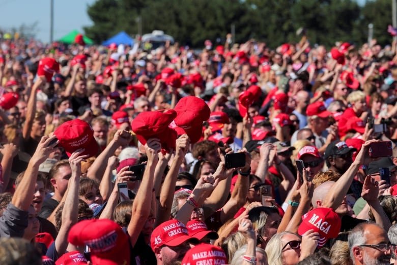 People wave red caps in crowd