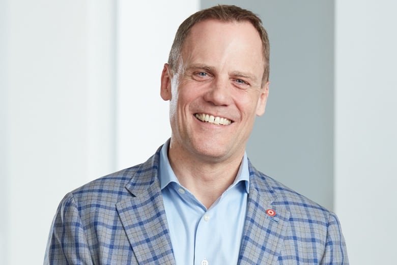 bret-leech Headshot of a man in a suit smiling.