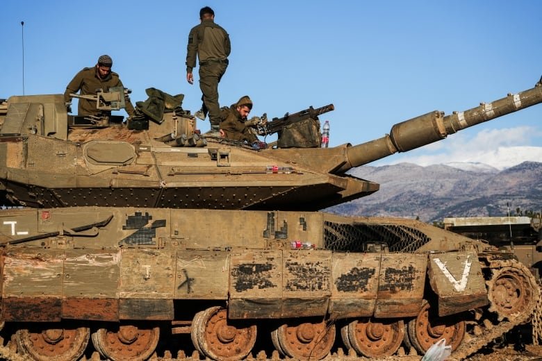 Soldiers work on a tank.