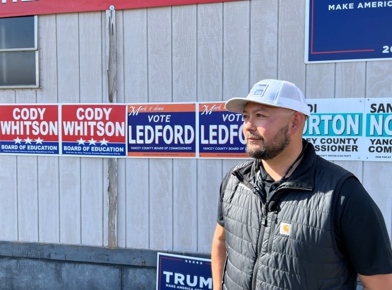 north-carolina-helene-voting-3 A person is pictured standing in front of a building adorned with political signs.