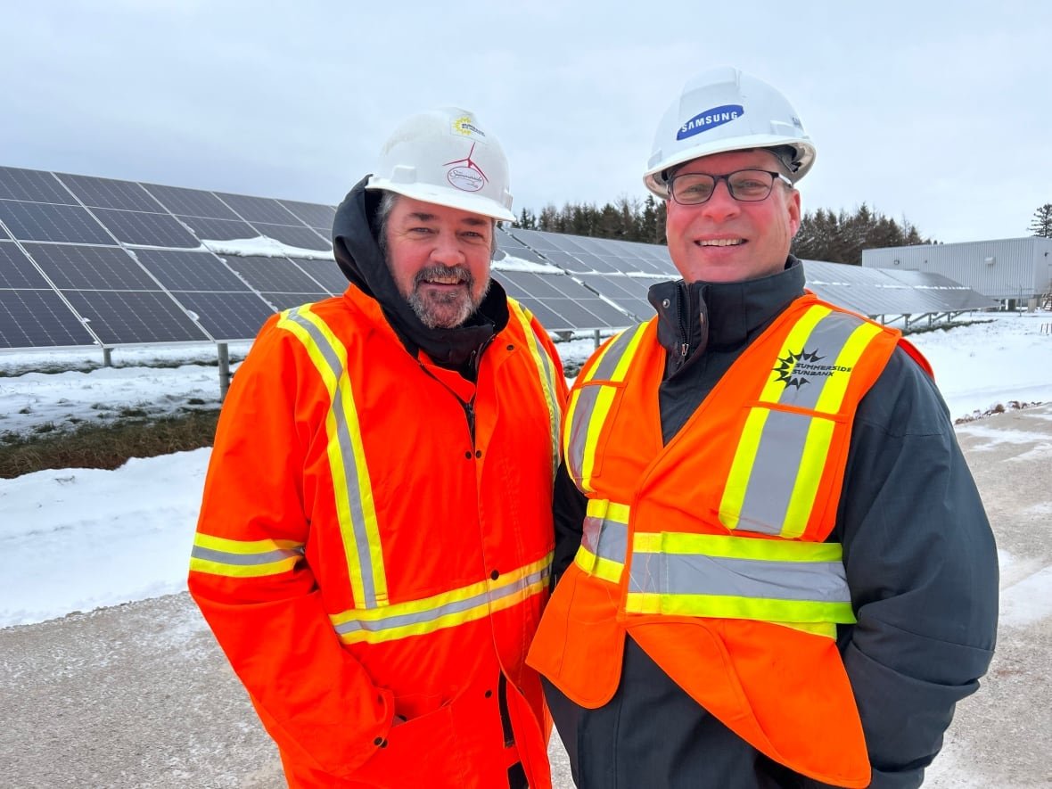 city-officials-at-sunbank Greg Gaudet director of municipal service and Mike Thususka Director of Economic Development stand by solar panels