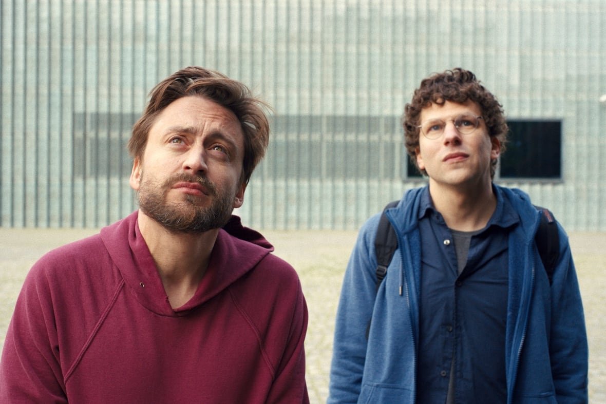 film-review-a-real-pain Two men look at something beyond the camera pointed at them.