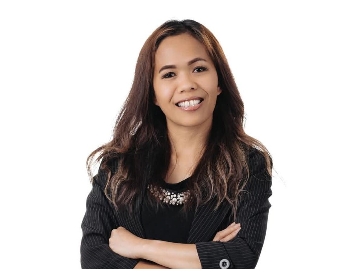 raquel-narraway A posed portrait of a Filipino realtor wearing dark business attire.
