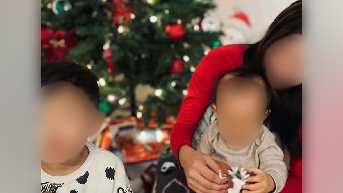 reyna-dela-pe-a An image of a woman with two children in front of a Christmas tree.