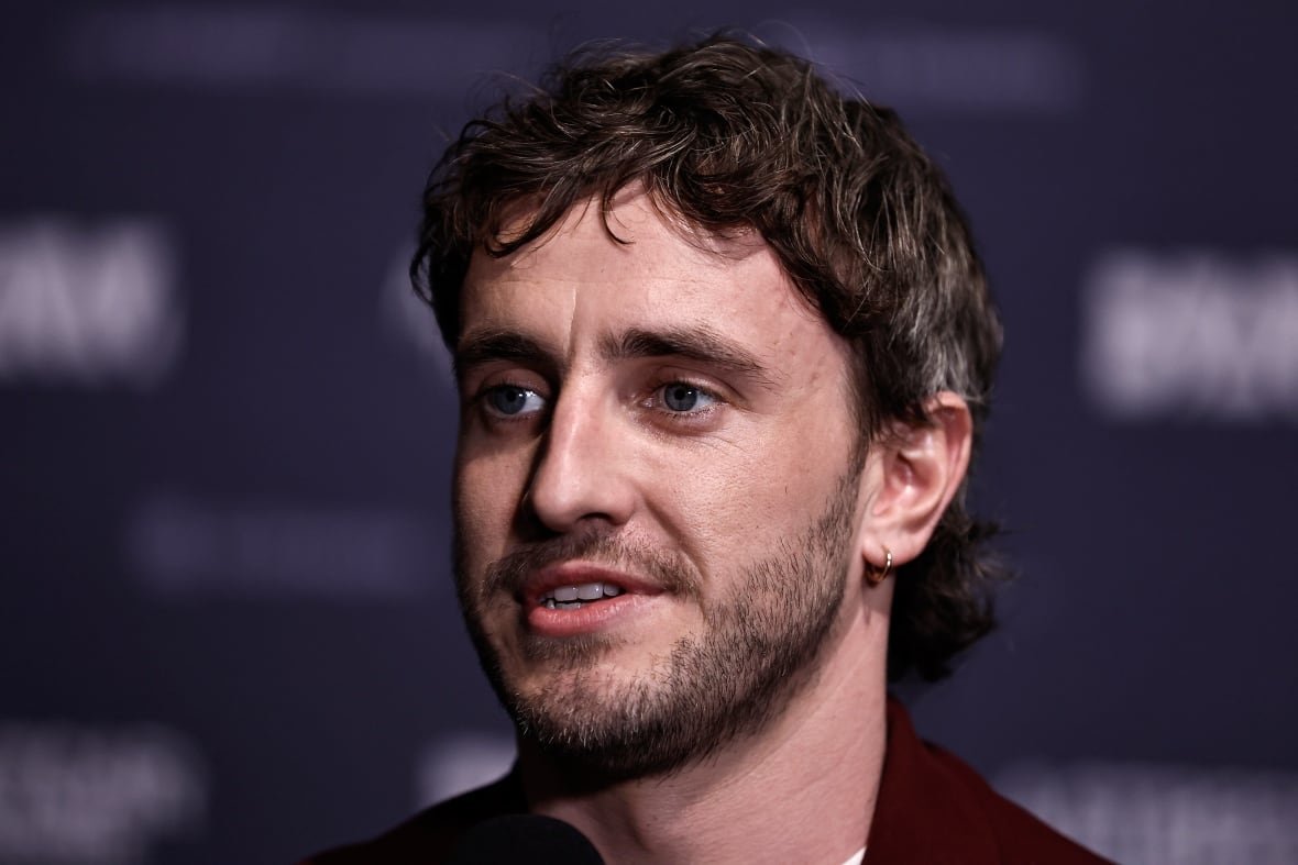 2204604320 A young man with facial hair is shown in closeup.