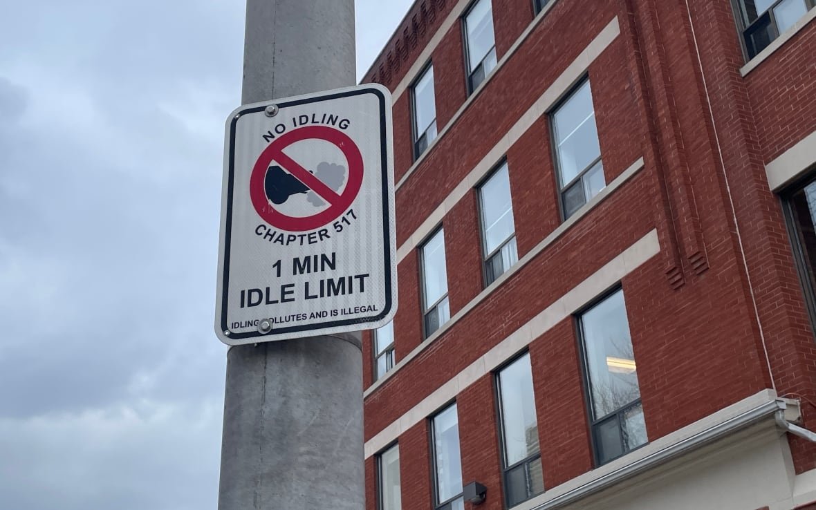 anti-idling-bylaw-sign-in-toronto Anti-idling bylaw sign on a lamppost beside a building.