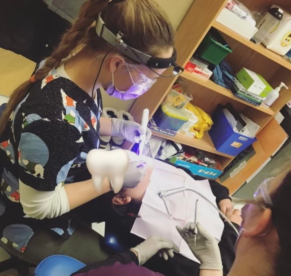 camille-poirier-2 A woman cleaning a child's teeth.