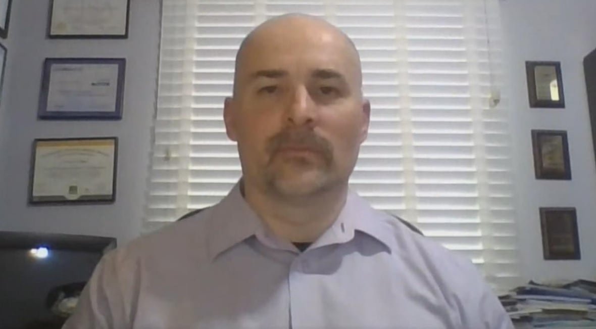 Headshot of man on webcam in office.