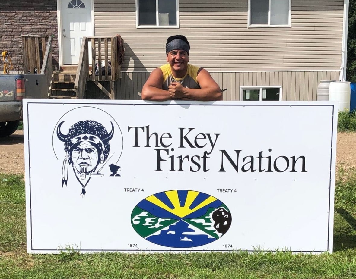 david-howard-cote A man stands behind a large First Nations sign.