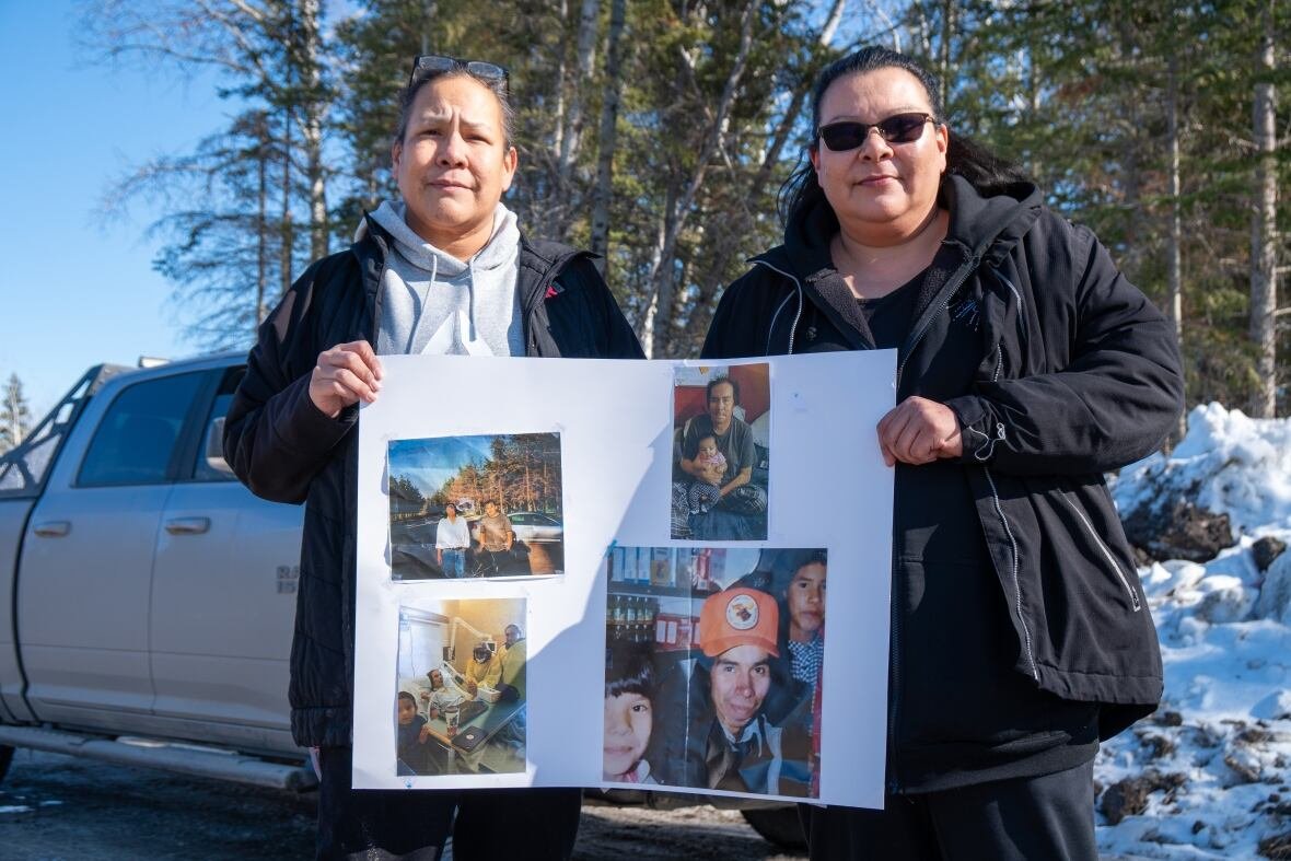 emily-and-sherry-fobister Two people are seen standing outside, holding a poster with photos on it.