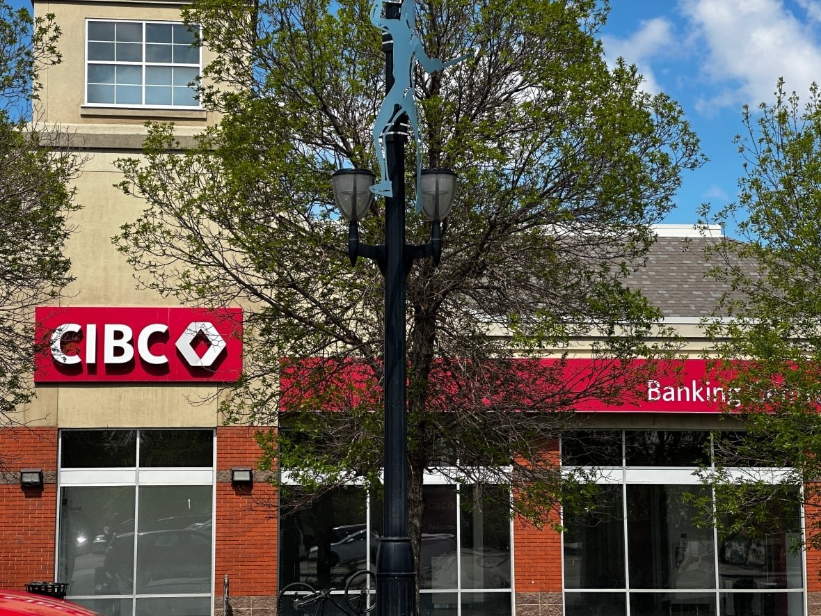 A CIBC bank is located on a tree-lined street.