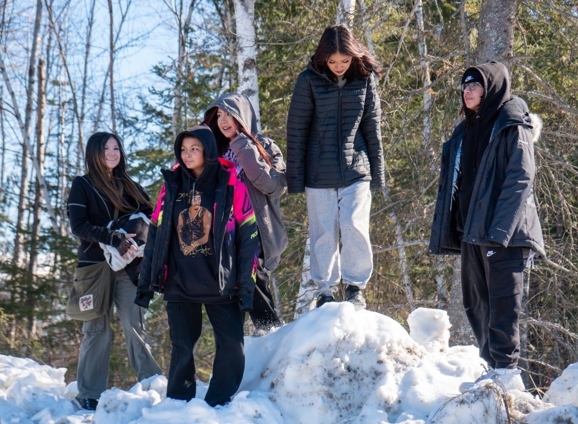 grassy-narrows-youth Five people are seen standing on a snow bank.