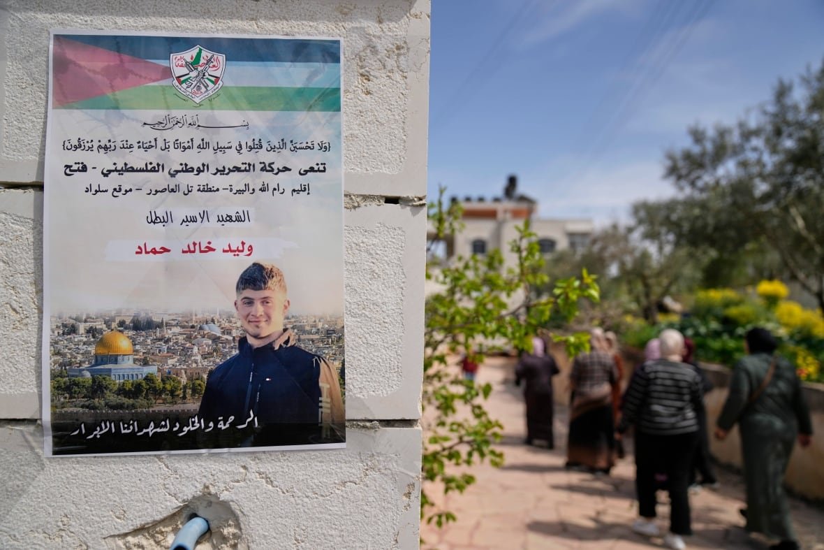 israel-palestinians-teenage-prisoner-dies-2 People walk past a poster.