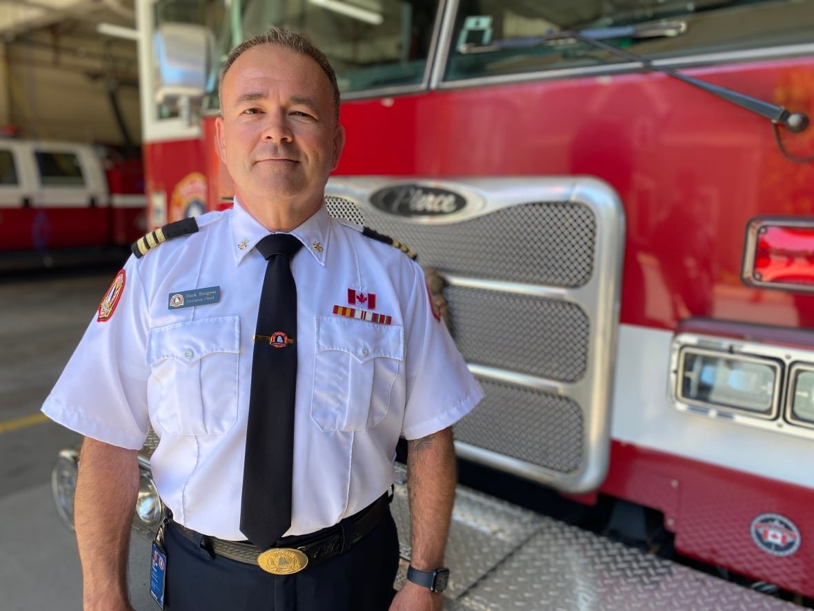 mark-burgess A man in a Halifax Fire uniform stands in front of a fire truck.