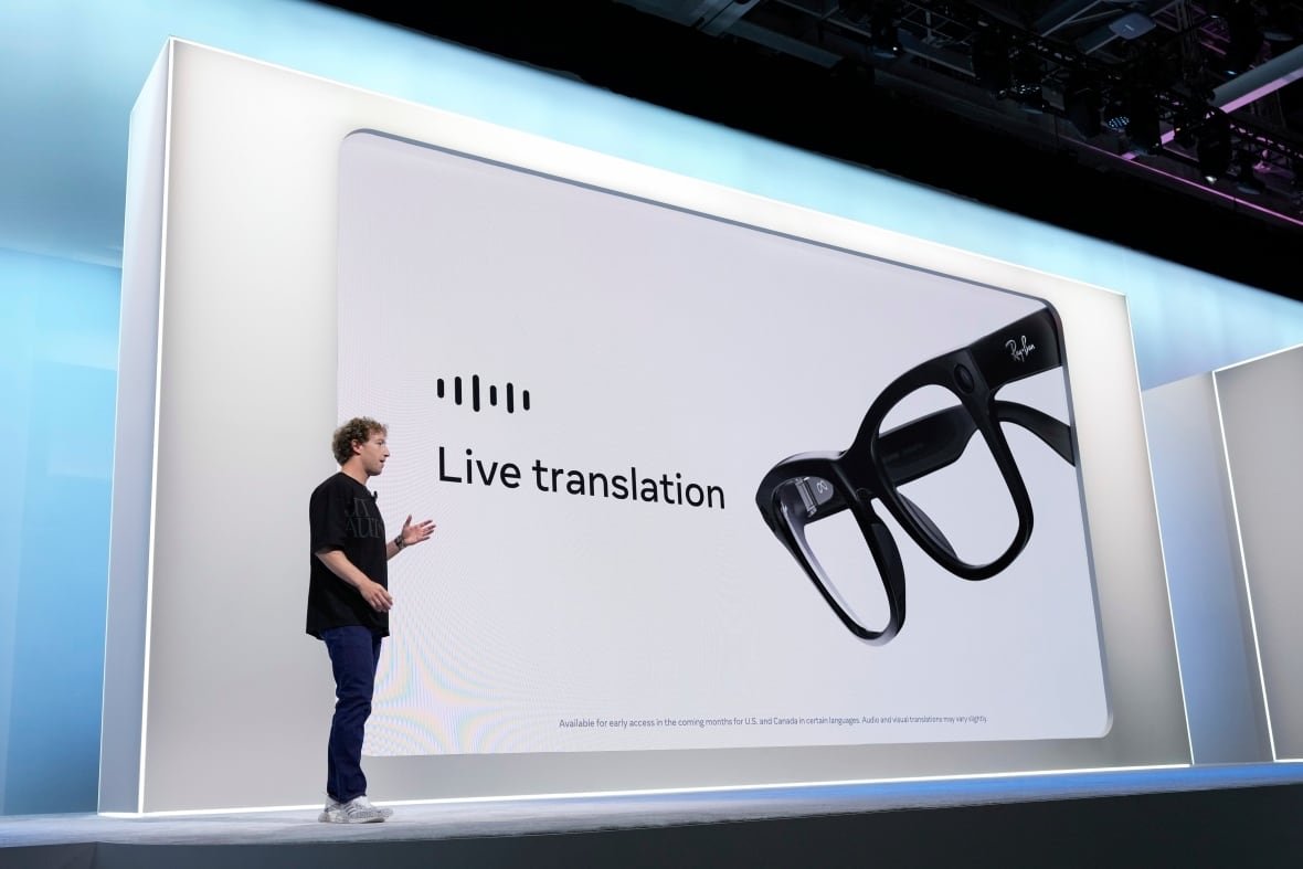 meta-connect-conference A man in plain clothing stands in front of a large screen that says "Live translation" next to a pair of glasses