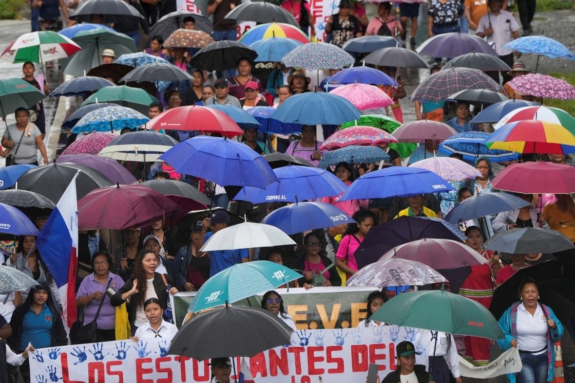 panama-workers A street full of people holding umbrellas and protest signs