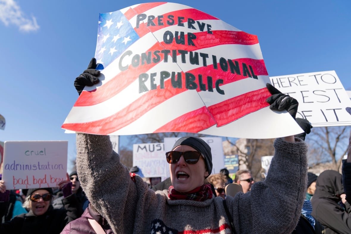 presidents-day-protest A demonstrator holds up a sign that reads, 'Protect Our Constitutional Republic,' during a protest.