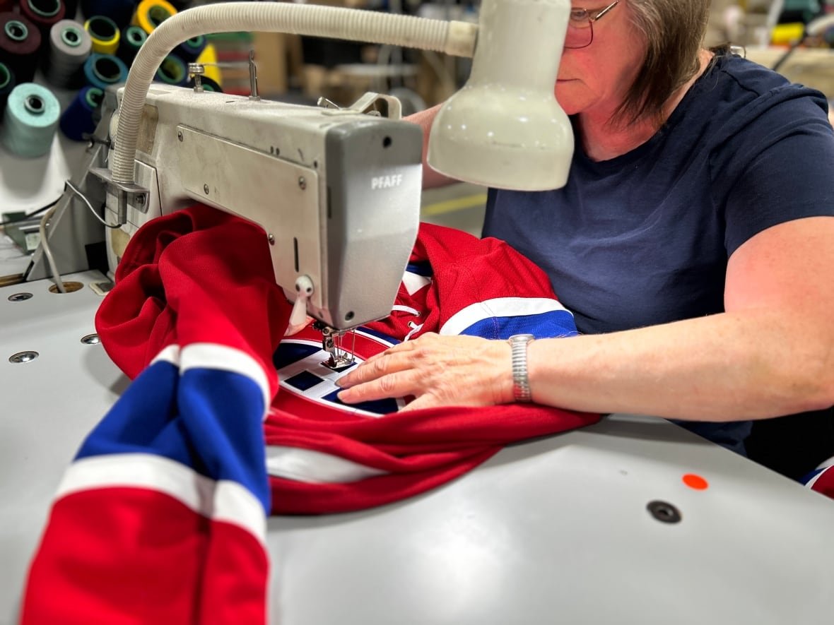 sewing-jersey Woman sews hockey jersey with Canadiens logo