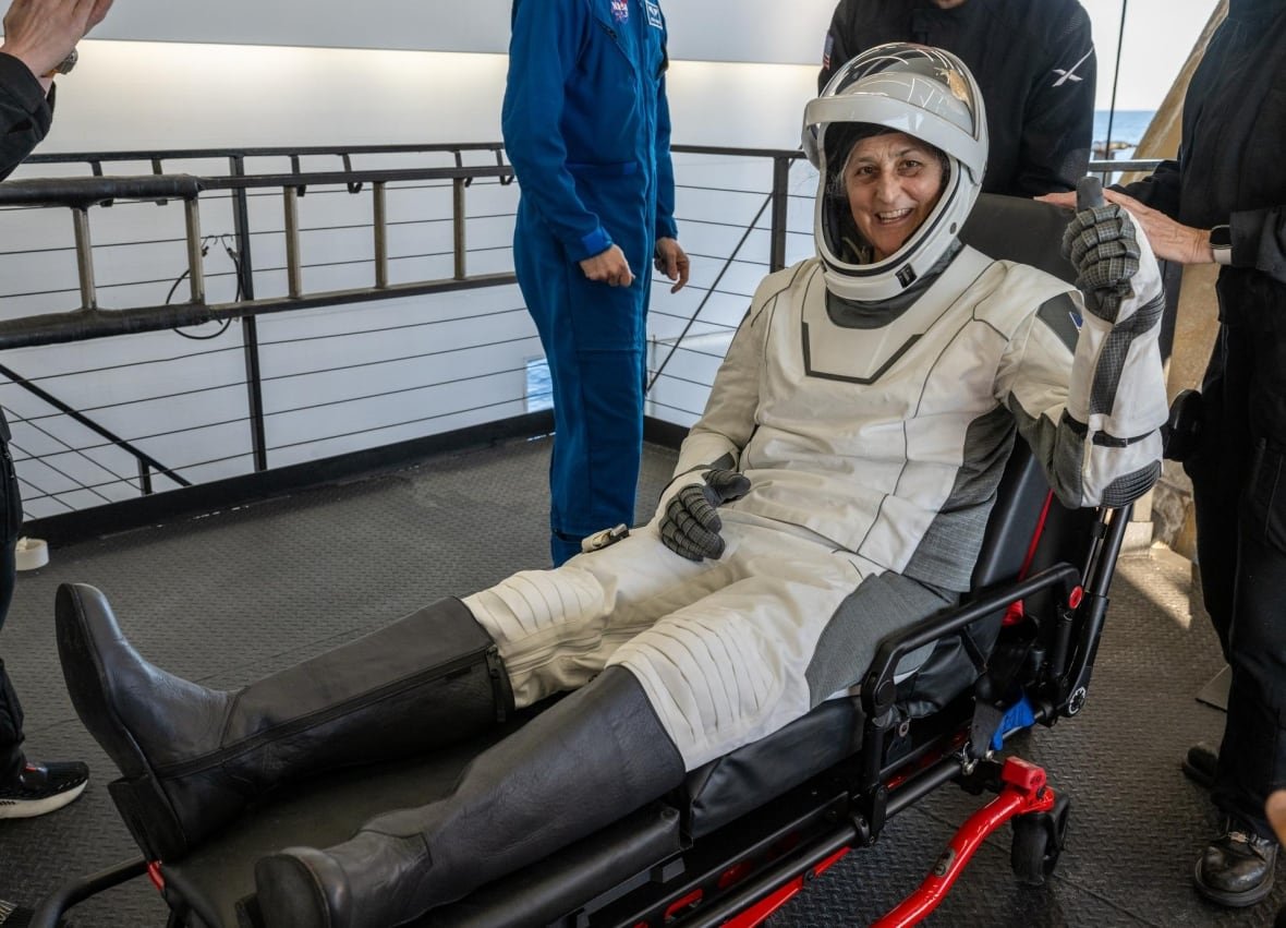 suni-williams-splashdown An astronaut gives the thumbs up while sitting up on a gurney.