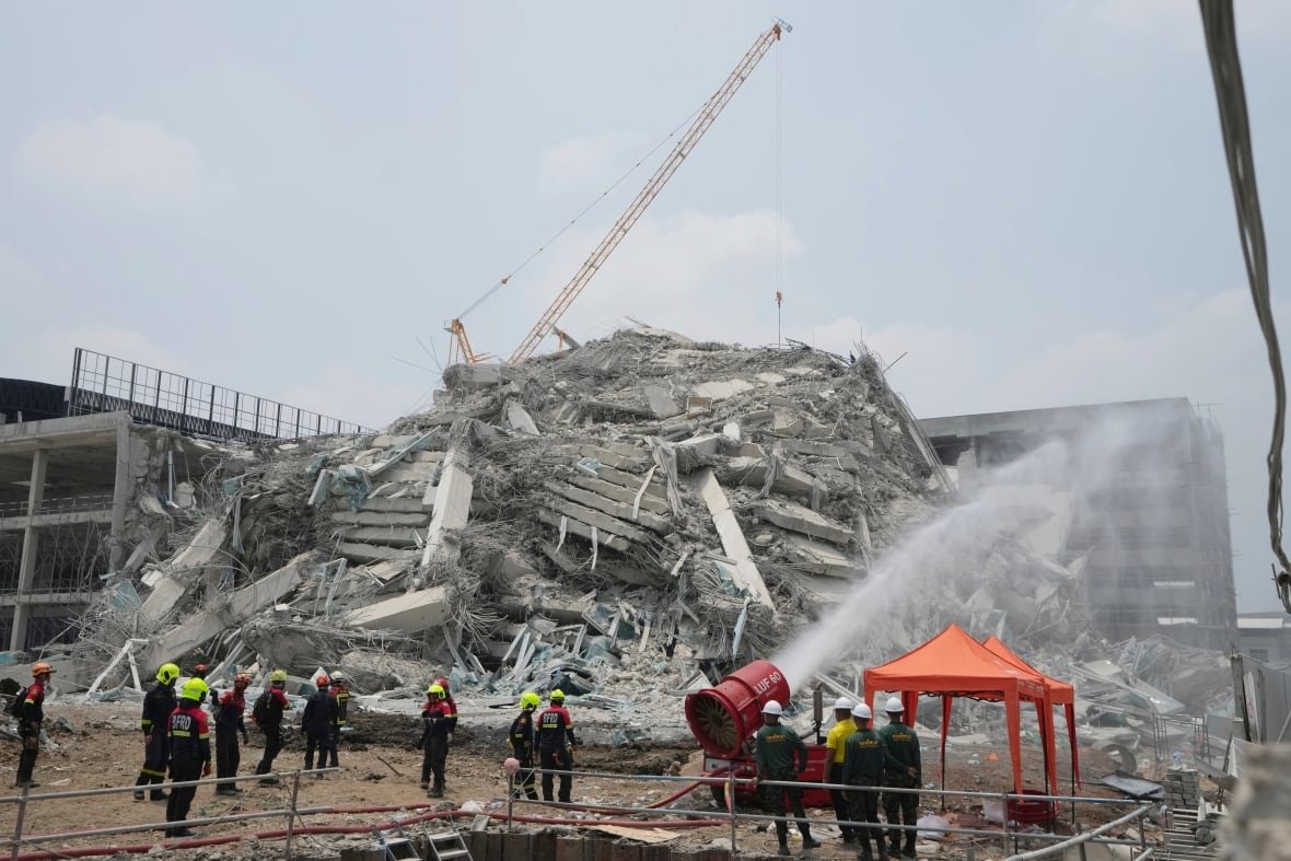 thailand-southeast-asia-earthquake-1 Workers spray water on the rubble of a collapsed building.