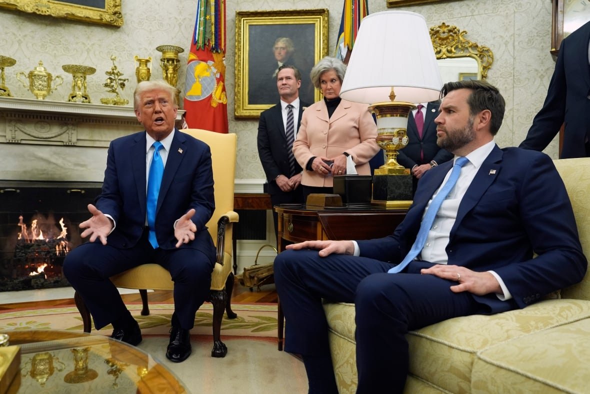 trump-vance Two people seated in the White House while others stand behind.