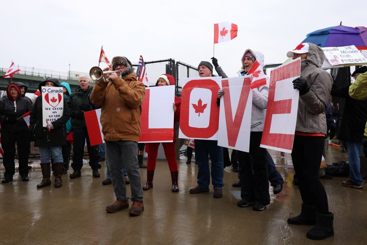 usa-trump-tariffs-canada People hold up maple leaves and the word 'LOVE'