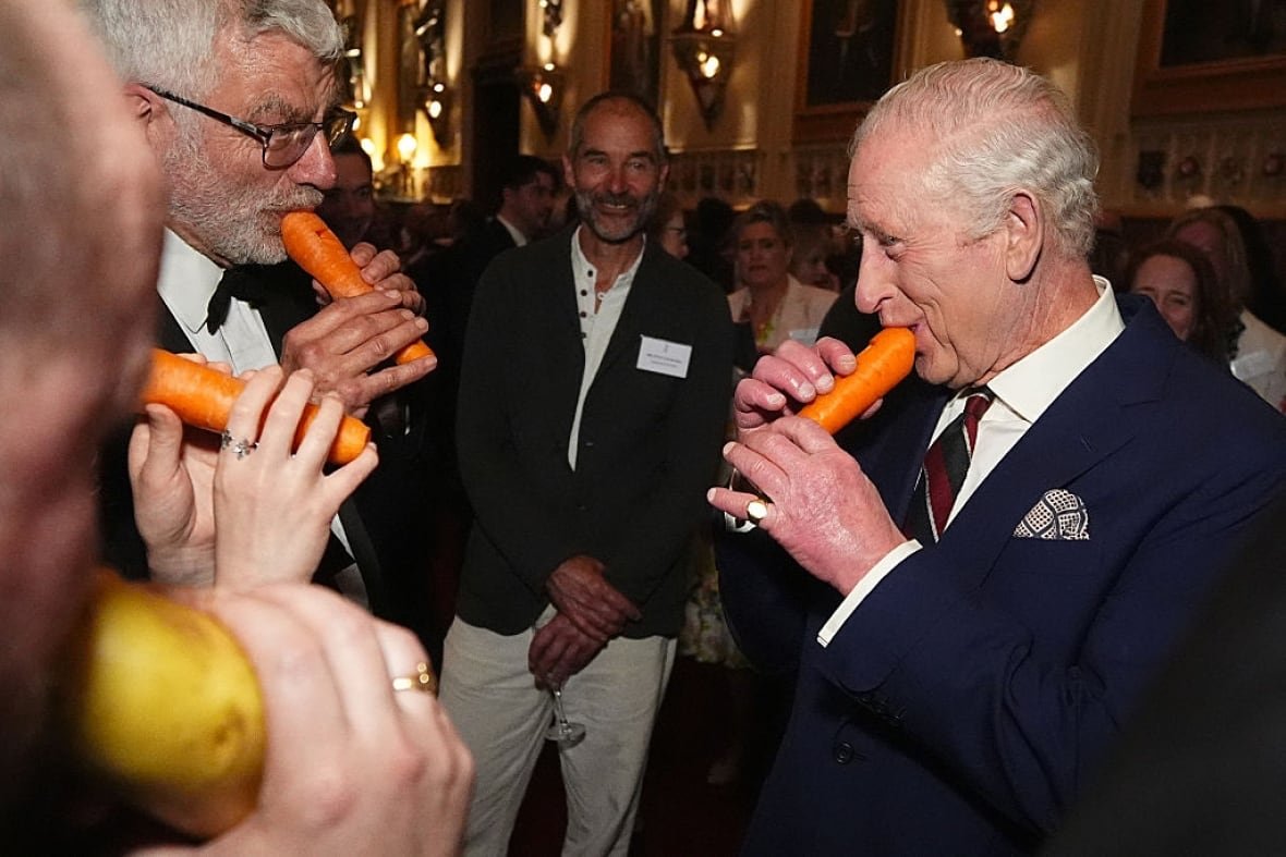 2207722067 Several people hold vegetables that have been carved to create musical instruments to their mouths.