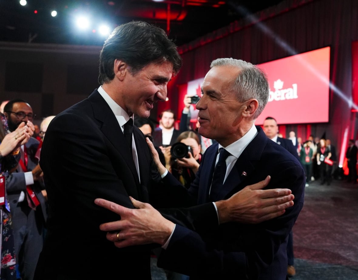 canada-politics Two people embrace as photographers and onlookers gather around.