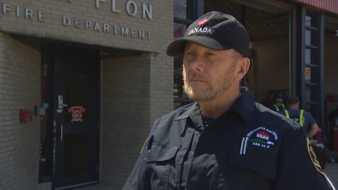 Man wearing back and red "Canada" hat wears black button up shirt with white writing on the chest.