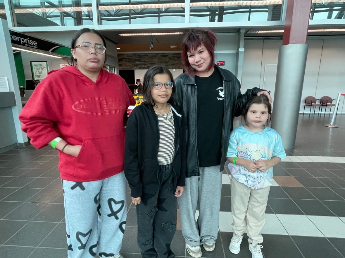 evacuees-from-sandy-lake-first-nation Four people are seen standing inside an airport.