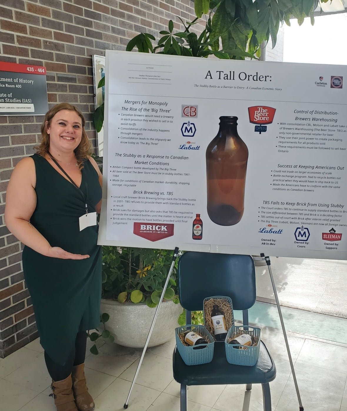 A woman standing beside a bristol board explainer about how the stubby was a non-tariff barrier to trade.