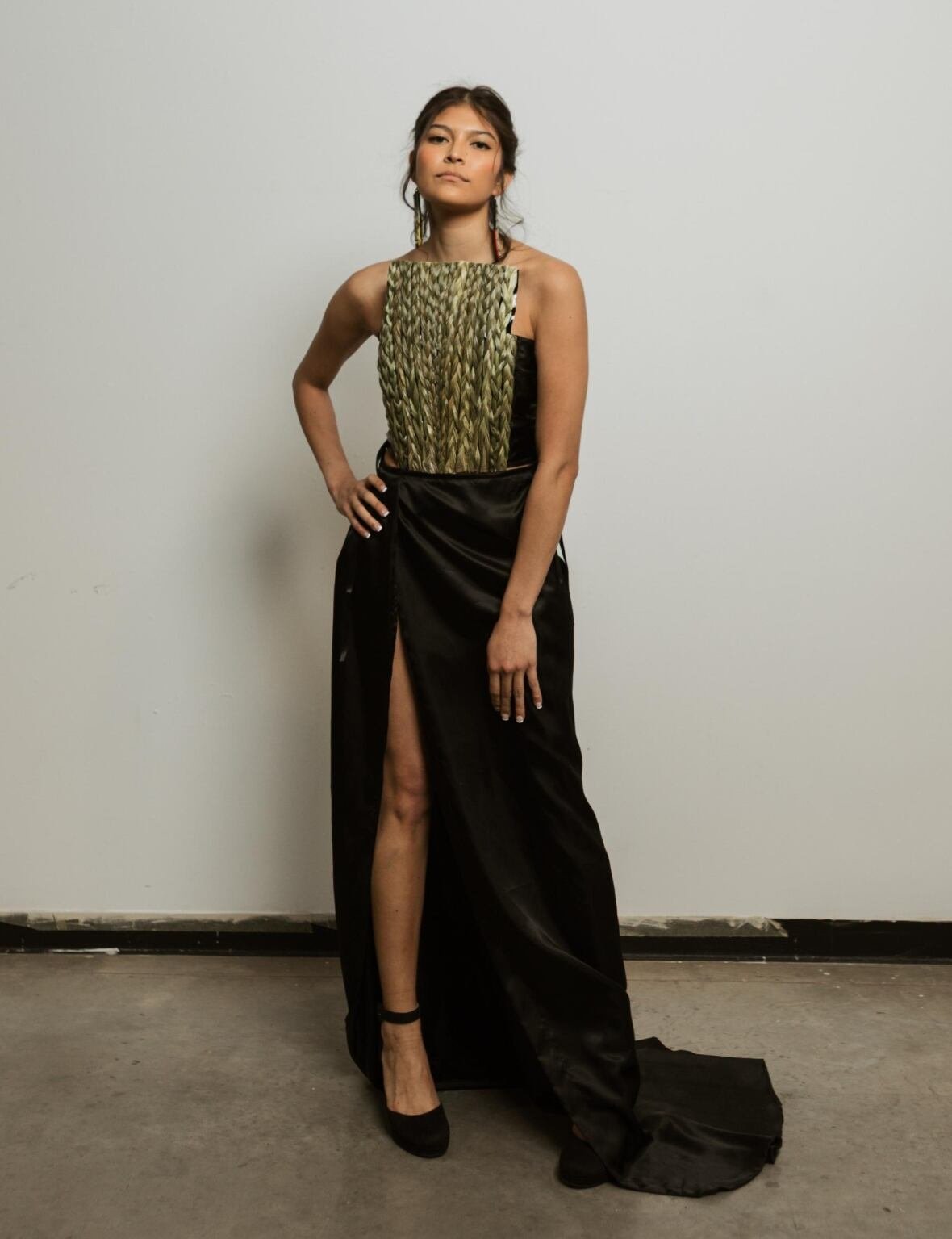 melrene-saloy-eaglespeaker-2 A model wears a long black dress with a breastplate made of braids of sweetgrass.