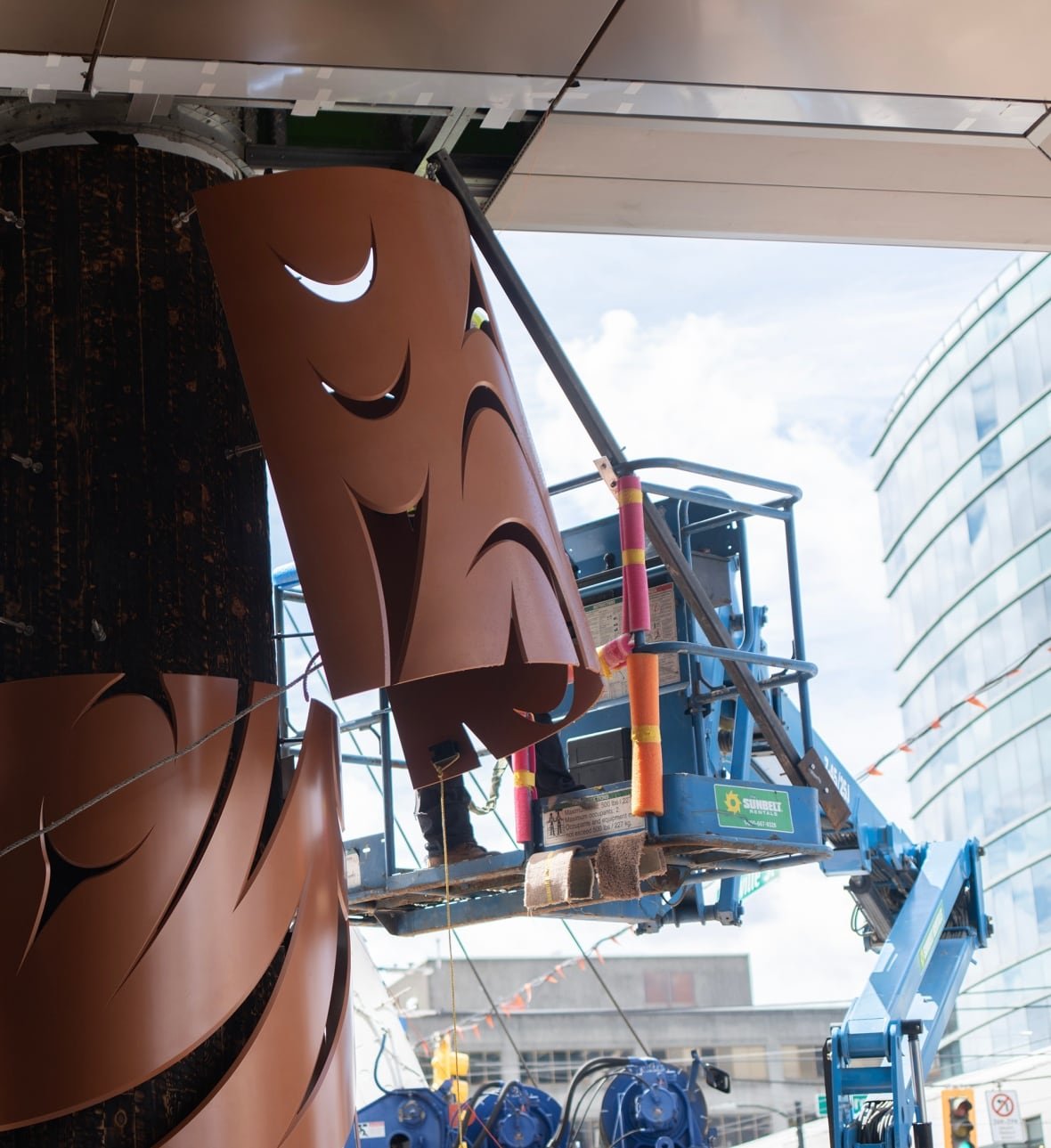 sinulh-ay-40-foot-sculpture-installation A boom lift installs sections of a large sculpture.