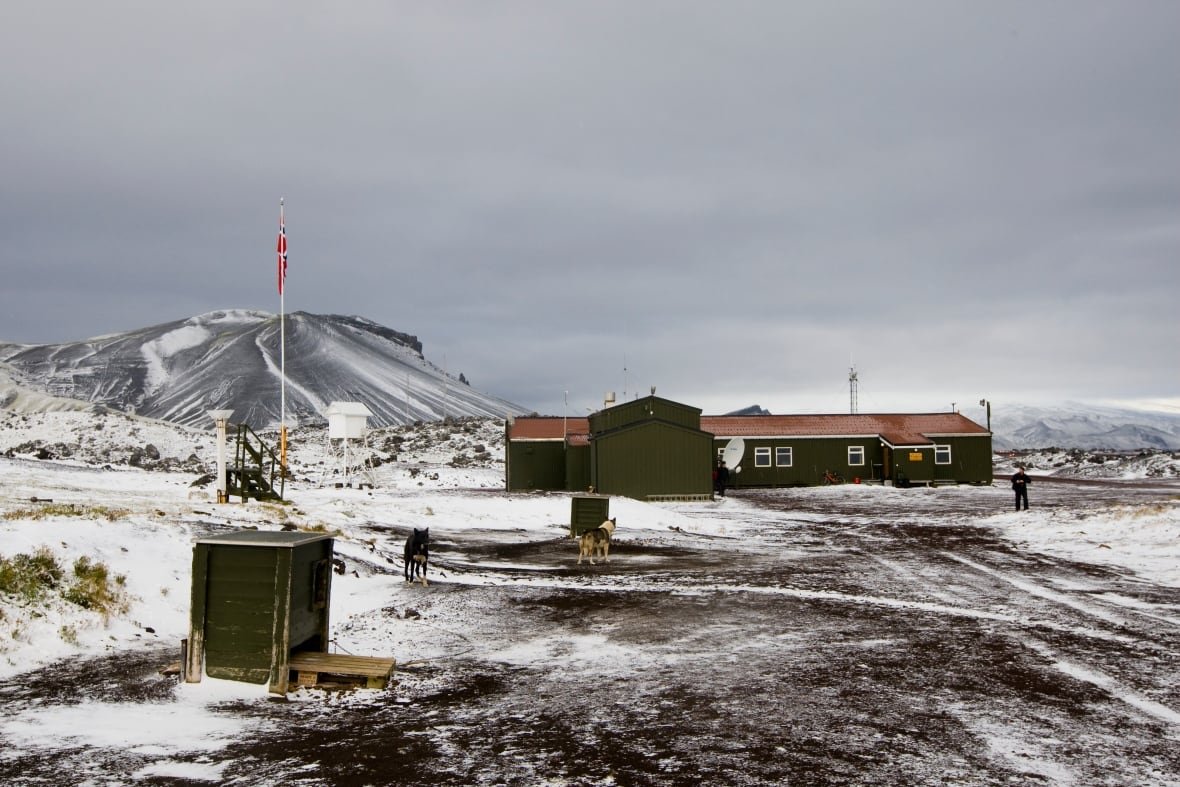 A small low building on a snowy landscape