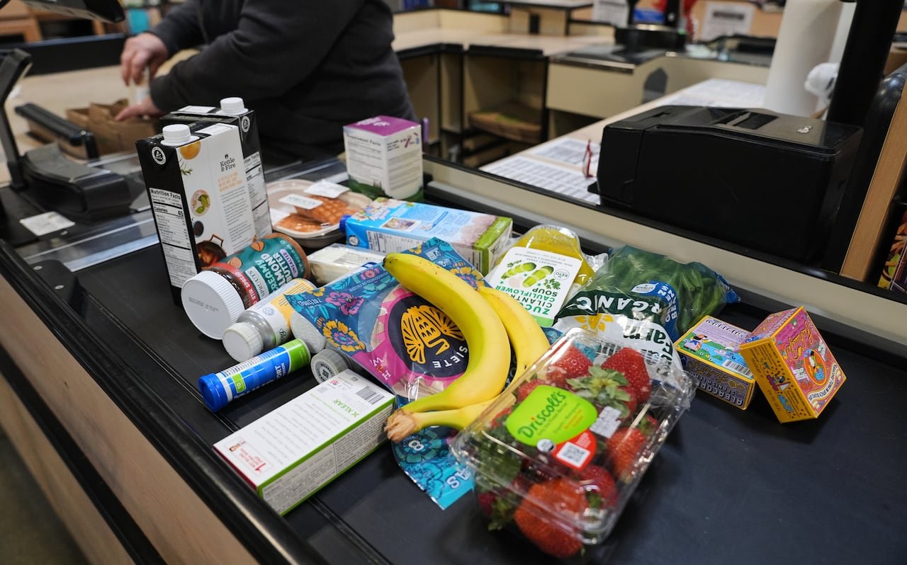 default-145 Bananas, strawberries and other grocery items at a supermarket checkout.