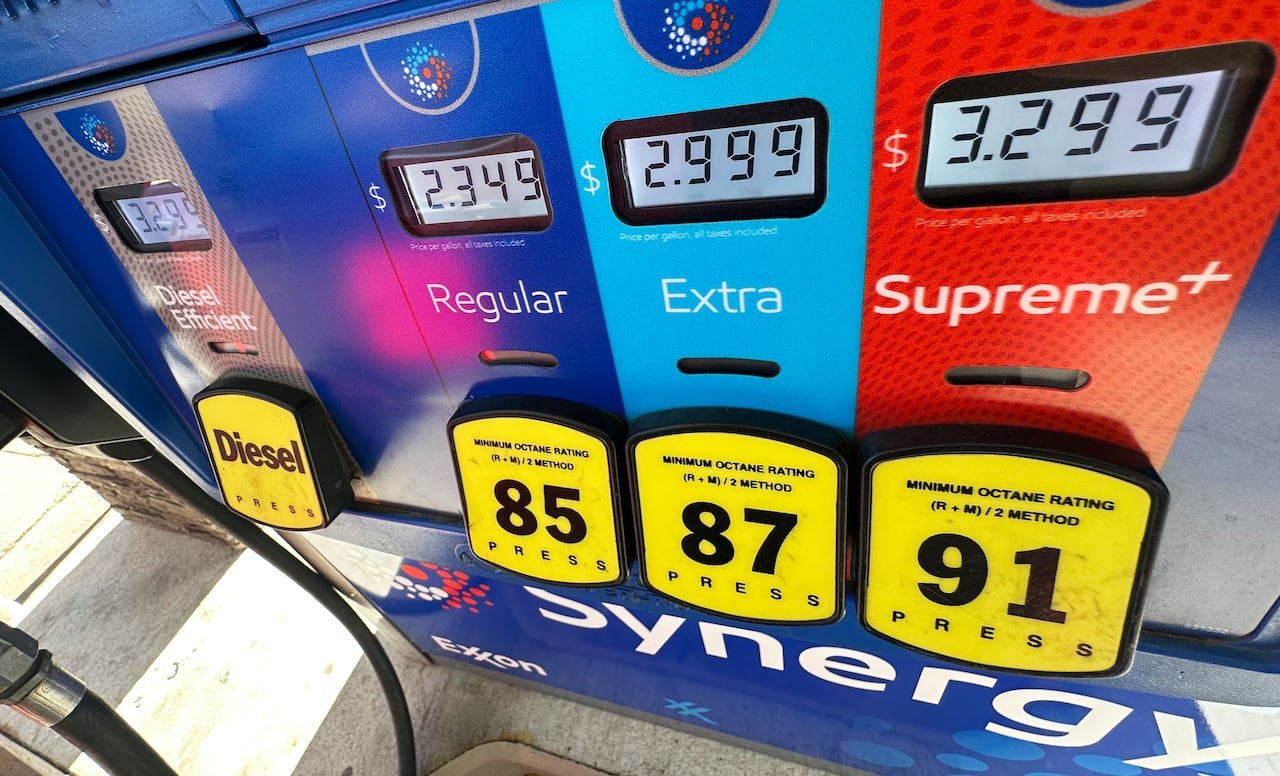 default-146 A pump displaying prices of $2.399 per gallon for regular gasoline, $2.999 for extra grade, and $3.299 for supreme+ grade.