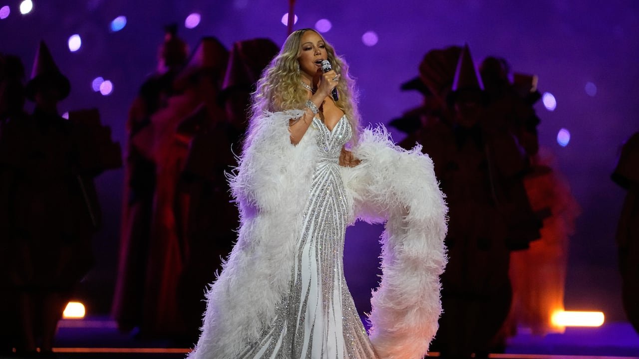 singer in bedazzled white gown and feather boa sings in front of purple backdrop at  opening ceremony at the 2026 Winter Olympics, in Milan, Italy