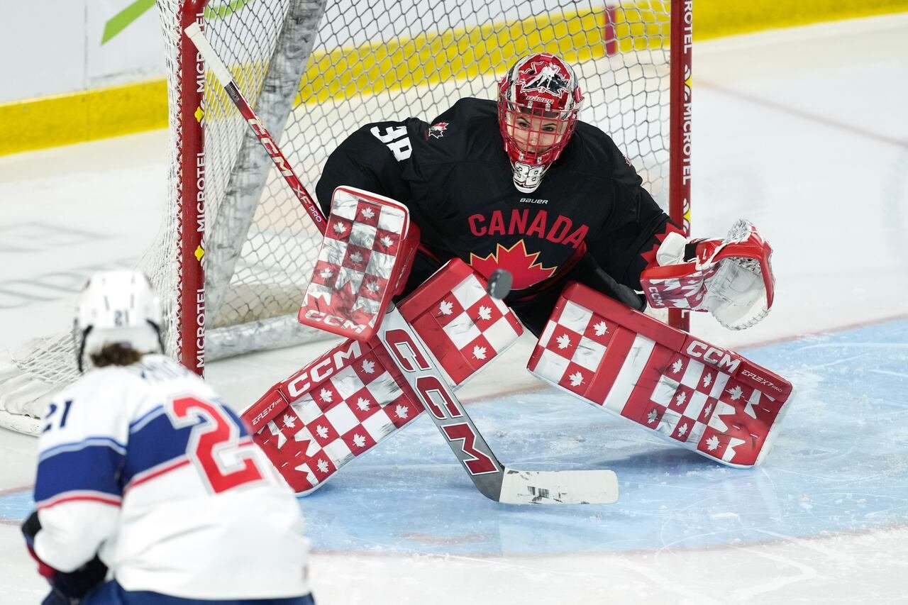 default-75 A goaltender for Team Canada makes a save during a hockey game.