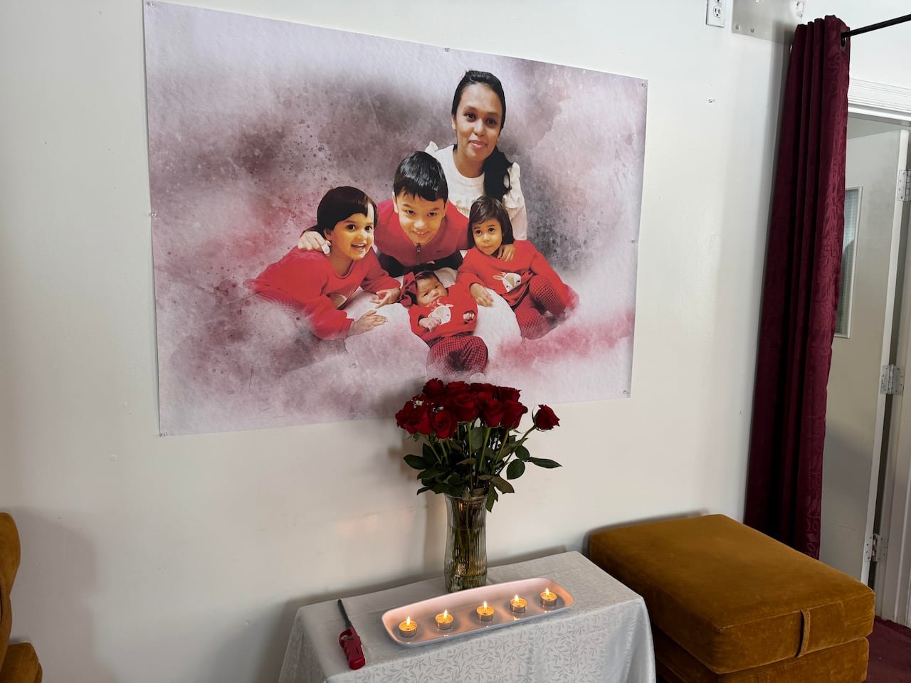 A family photo, roses and candles are on display in honor of those killed in the tragedy.