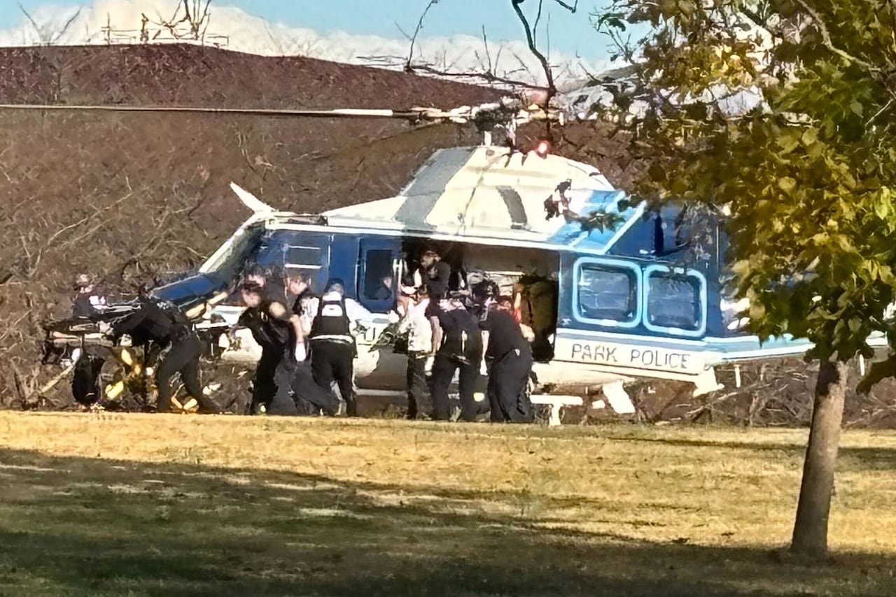 default-277 From a distance a helicopter is shown, with a stretcher, and several first responders around it.