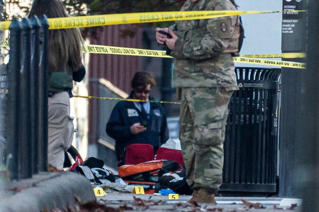 default-278 Police tape and items that have been tagged with numbers are shown on a sidewalk.